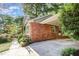Attached carport made of brick, ample concrete space, and adjacent landscaping at 1324 Swallow Dr, Raleigh, NC 27606