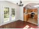 Dining room with gleaming wood floors, contemporary chandelier, and French doors leading to the yard at 1324 Swallow Dr, Raleigh, NC 27606