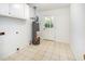 Utility room with tiled floor, water heater, and overhead cabinets at 1324 Swallow Dr, Raleigh, NC 27606