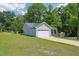 View of the front exterior with garage, concrete driveway, light siding, and mature trees at 15 Nottingham Pl, Smithfield, NC 27577