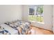 Well-lit bedroom with natural light from the window, wood flooring and a patterned comforter at 1508 Malta Ave, Raleigh, NC 27610