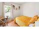This small bedroom has a natural light from the windows, a golden bed and a dark wood desk at 1508 Malta Ave, Raleigh, NC 27610