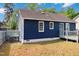 Back exterior of a blue home with a wood deck and a grassy lawn at 1508 Malta Ave, Raleigh, NC 27610