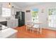 Bright kitchen displays plenty of light with gray cabinets, stainless appliances, wood flooring and a breakfast table at 1508 Malta Ave, Raleigh, NC 27610