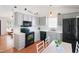Well-lit kitchen boasts stainless steel appliances and light gray cabinetry with white countertops and wood flooring at 1508 Malta Ave, Raleigh, NC 27610