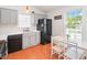 Bright kitchen shows cabinetry with a black refrigerator, wood flooring and a breakfast nook with natural light at 1508 Malta Ave, Raleigh, NC 27610