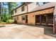 Brick and vinyl sided home with a large patio and tall mature trees at 1604 Westbridge Ct, Raleigh, NC 27606