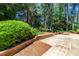 Brick retaining wall holds healthy bushes and mature trees at 1604 Westbridge Ct, Raleigh, NC 27606