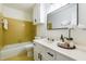 Bright bathroom with a white vanity, a toilet, and a bathtub with yellow tiling at 1604 Westbridge Ct, Raleigh, NC 27606