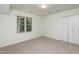 Bedroom with plush carpeting, a window with a backyard view, and a double-door closet at 1604 Westbridge Ct, Raleigh, NC 27606