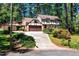 Charming Tudor-style home featuring a two-car garage, a porte-cochère, and a beautifully landscaped front yard at 1604 Westbridge Ct, Raleigh, NC 27606