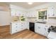Bright kitchen with white cabinets, black appliances, light countertops, and wood floors at 1604 Westbridge Ct, Raleigh, NC 27606