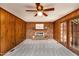 Cozy living room with brick fireplace, wood paneling, and a ceiling fan at 1604 Westbridge Ct, Raleigh, NC 27606