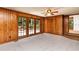 Living room featuring wood paneled walls and access to the outdoor area at 1604 Westbridge Ct, Raleigh, NC 27606