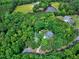 Aerial view showcases the property surrounded by lush greenery and a serene pond at 168 E Deer, Apex, NC 27523
