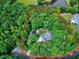 Aerial view of a wooded property with a lovely house surrounded by trees and a pond in the background at 168 E Deer, Apex, NC 27523