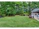 Lush backyard with well-manicured lawn, mature trees, and a glimpse of the home's deck at 168 E Deer, Apex, NC 27523
