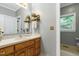 Well-lit bathroom featuring a vanity and mirror with decorative accents and a view of outside at 168 E Deer, Apex, NC 27523