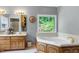 Bright bathroom boasts a soaking tub with a large window view, vanity, and neutral color palette at 168 E Deer, Apex, NC 27523