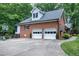 Side view of a brick home with a two-car garage, basketball hoop, and well-manicured lawn at 168 E Deer, Apex, NC 27523