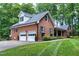 Brick home features a two-car garage, well-manicured lawn, and mature landscaping at 168 E Deer, Apex, NC 27523