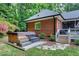 Outdoor hot tub with wooden surround and stone pathway, set against a backdrop of mature landscaping at 168 E Deer, Apex, NC 27523