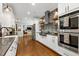 Spacious white kitchen with stainless steel appliances and a view into the living room at 168 E Deer, Apex, NC 27523