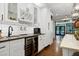 Kitchen boasts a wine fridge, beverage taps, white subway tile backsplash, and seamless flow to living area at 168 E Deer, Apex, NC 27523