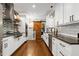 Modern kitchen boasts subway tile backsplash, floating shelves, a gas range, and a wood sliding barn door at 168 E Deer, Apex, NC 27523