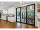 Kitchen boasts stainless steel appliances, lots of natural light, white cabinetry, and views to the sun room at 168 E Deer, Apex, NC 27523