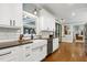 Spacious kitchen with white cabinetry, a farmhouse sink, and stainless steel appliances at 168 E Deer, Apex, NC 27523