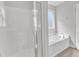 Bright bathroom featuring a glass enclosed shower and soaking tub at 172 Wellons Creek Dr, Garner, NC 27529
