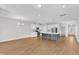 Bright open-concept kitchen with white cabinets, stainless steel appliances, and a large center island with pendant lighting at 172 Wellons Creek Dr, Garner, NC 27529