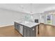Kitchen island featuring a sink, dishwasher and room for seating with sight lines to the living room at 172 Wellons Creek Dr, Garner, NC 27529