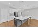 Open kitchen with white cabinets, a gray tiled backsplash, and an island with seating at 172 Wellons Creek Dr, Garner, NC 27529