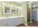 A bright, green-walled bathroom with double vanity, white cabinets, and framed mirrors provides a functional design at 1732 Bobwhite Ln, Rocky Mount, NC 27804