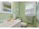 Bathroom featuring fresh green paint, white vanity and plenty of natural light at 1732 Bobwhite Ln, Rocky Mount, NC 27804