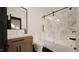 Modern bathroom featuring marbled tile, black hardware, and a combination tub and shower at 1802 Pershing Rd, Raleigh, NC 27608