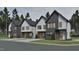 Street view of modern two-story homes featuring a mix of gray brick and white siding with manicured lawns at 1802 Pershing Rd, Raleigh, NC 27608