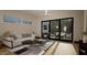 Sunlit living room with a plush sofa, modern coffee table, and glass sliding doors to patio at 1802 Pershing Rd, Raleigh, NC 27608
