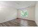 An interior bedroom with wood flooring and a window providing natural light and backyard views at 1910 Falls Landing Dr, Raleigh, NC 27614
