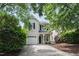 Charming two-story home with a well-manicured lawn and attached garage, framed by mature trees at 1910 Falls Landing Dr, Raleigh, NC 27614