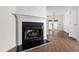 Close-up of a cozy fireplace in a bright living room with hardwood floors and a view of the backyard at 1910 Falls Landing Dr, Raleigh, NC 27614