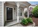 Inviting front porch featuring decorative trim, a dark front door, and lush landscaping at 1910 Falls Landing Dr, Raleigh, NC 27614