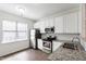 Well-lit kitchen featuring white cabinets, stainless appliances, and granite countertops at 1910 Falls Landing Dr, Raleigh, NC 27614