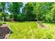 Expansive backyard featuring lush green lawn, mature trees, and beautiful landscaping at 2111 Woodland Ave, Raleigh, NC 27608