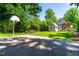 Large backyard with a basketball court, a well-maintained lawn, and views of the home's exterior at 2111 Woodland Ave, Raleigh, NC 27608