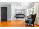 Bright bedroom with hardwood floors, neutral paint, ceiling fan, and cozy armchair with blue throw at 2111 Woodland Ave, Raleigh, NC 27608