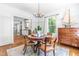 Elegant dining room with hardwood floors, chandelier, and abundant natural light from a large window at 2111 Woodland Ave, Raleigh, NC 27608