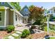 Home exterior with a backyard patio, lush landscaping, and charming architectural details at 2111 Woodland Ave, Raleigh, NC 27608